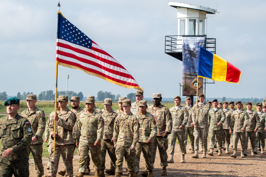 U.S. Soldiers assigned to Bravo Battery, 1st Battalion, 5th Field Artillery Regiment, 1st Armored Brigade Combat Team, 1st Infantry Division, Task Force Iron, march with Romanian Soldiers during Bemowo Piskie Training Area Day at BPTA, Poland, Sept. 12, 2025. Bemowo Piskie Training Area hosts more than 1,200 NATO troops from seven allied nations as part of the enhanced Forward Presence mission in Poland. The event underscored the multinational battle group’s commitment to building trust with the Polish community and NATO through professionalism and demonstrated capability. (U.S. Army National Guard photo by Sgt. Eric Allen)
